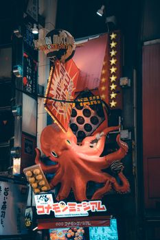 Colorful neon octopus sign drawing attention in a bustling cityscape. Perfect for travel and urban themes.