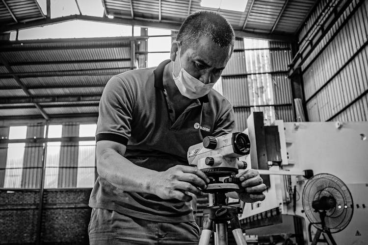 A Man Operating A Device In A Warehouse 