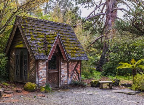 A quaint wooden cabin amidst lush greenery, perfect for a summer retreat.