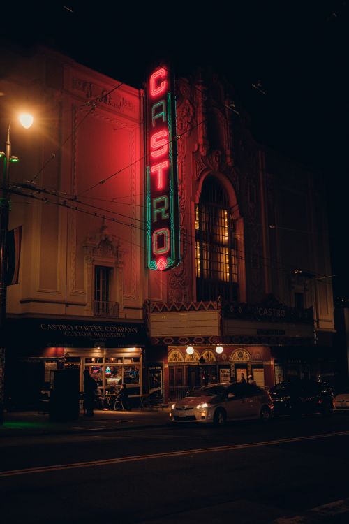 Free Vibrant neon signs illuminate the historic Castro Theatre's facade during a city night. Stock Photo