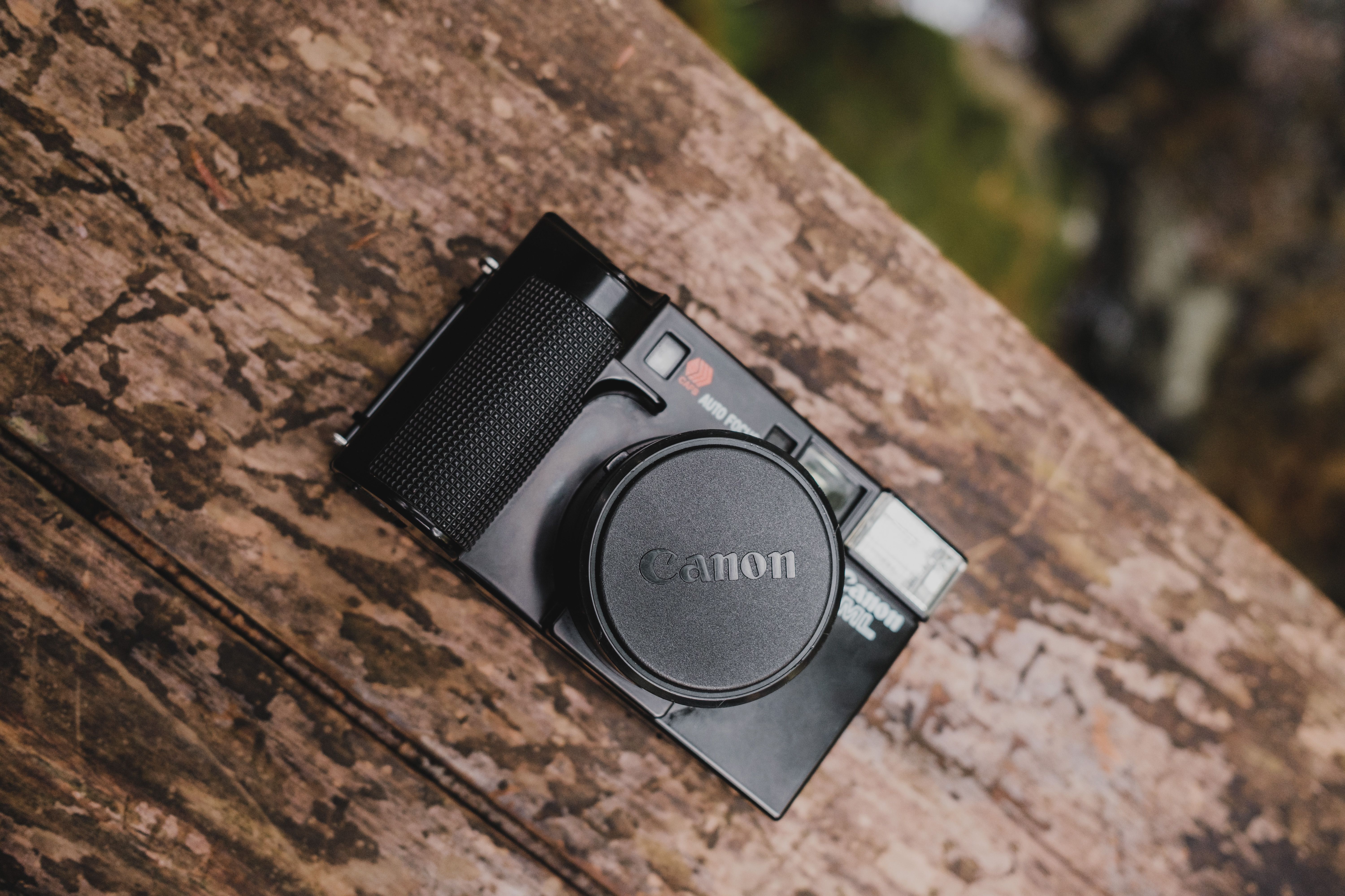 Top view of a classic Canon AE-1 film camera resting on a rustic wooden surface, showcasing its retro design.