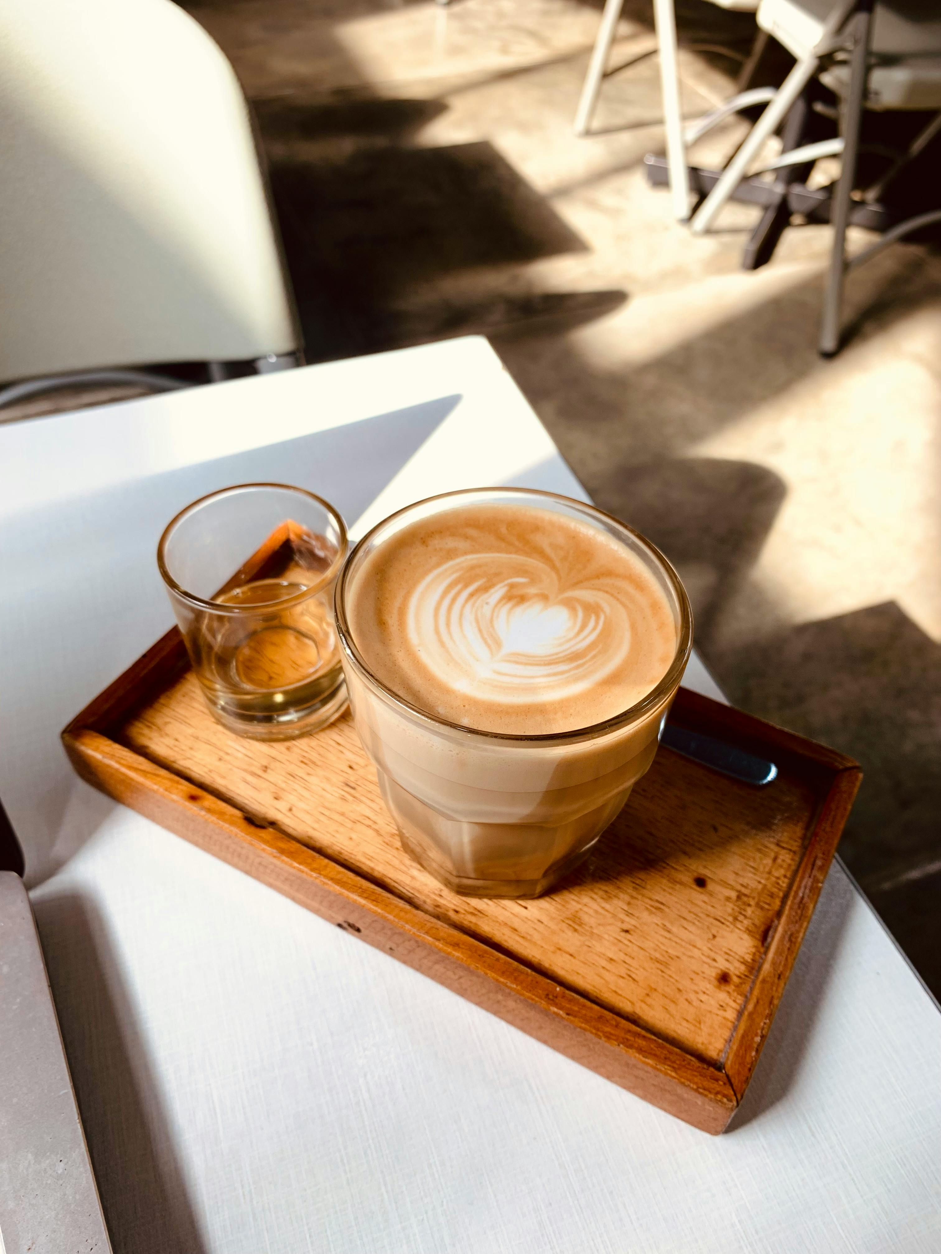 A perfectly crafted latte served on a wooden tray, capturing the essence of cafe culture.