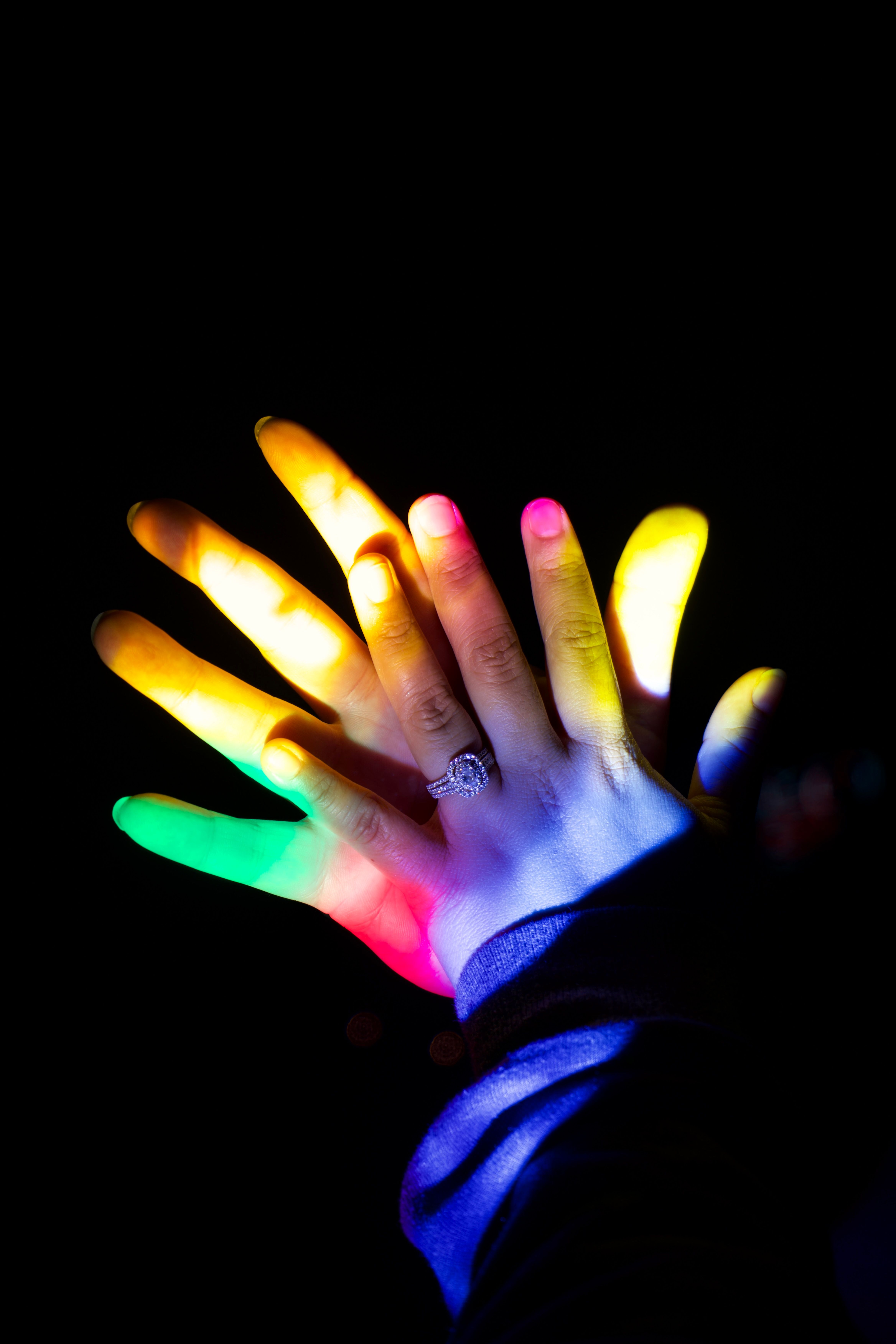Couple Hands in Colorful Light on Black Background · Free Stock Photo