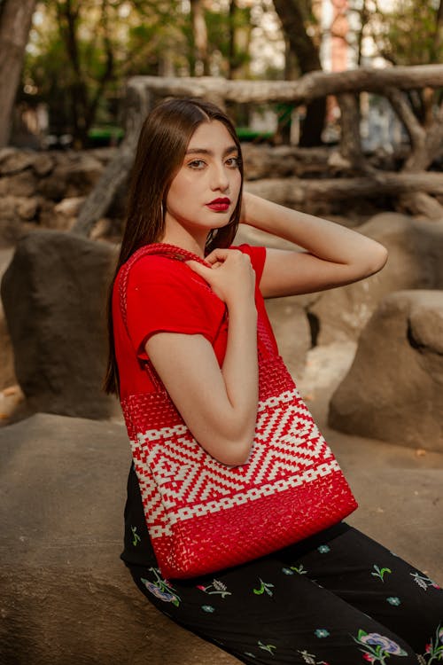 Young Brunette Holding a Red Bag with a Pattern 