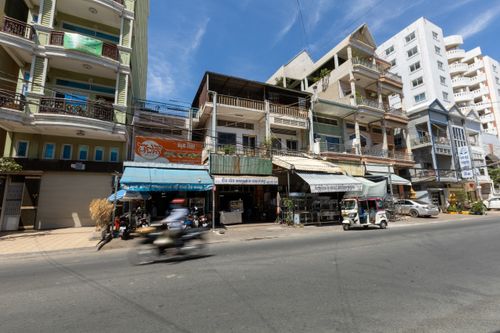 Free Daytime street in a city with motorbikes and buildings under a clear blue sky. Stock Photo