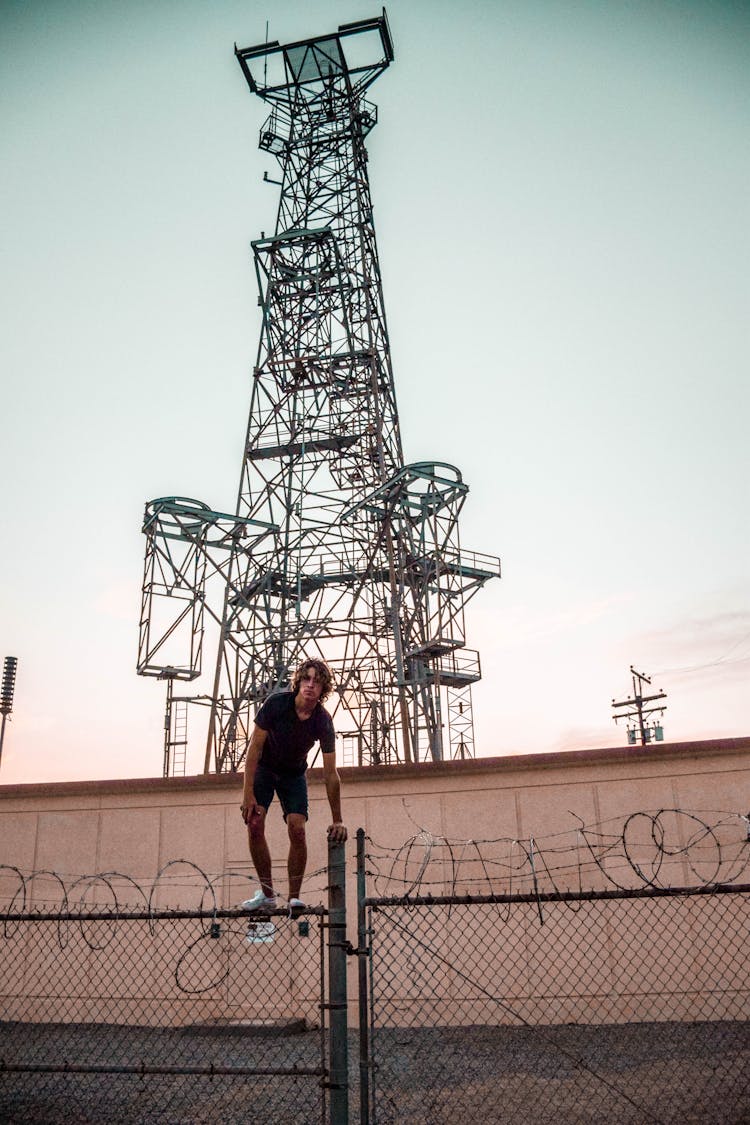 Person Standing On Steel Fence