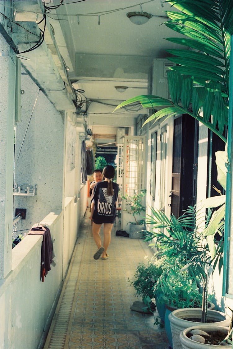 Woman Carrying A Child Walking Down The Hall