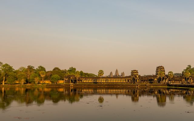 Photo: Serg Alesenko on Pexels Majestic Angkor Wat temple reflecting in calm waters at sunrise, showcasing ancient architecture.