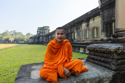 Buddhist Monk Sitting Crossed Legged on the Ground 