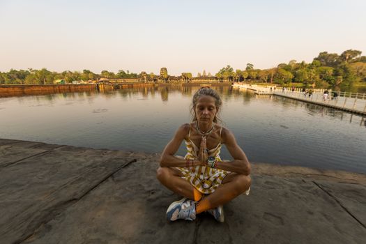 Woman Meditating in Front of an Ancient Temple in Cambodia 