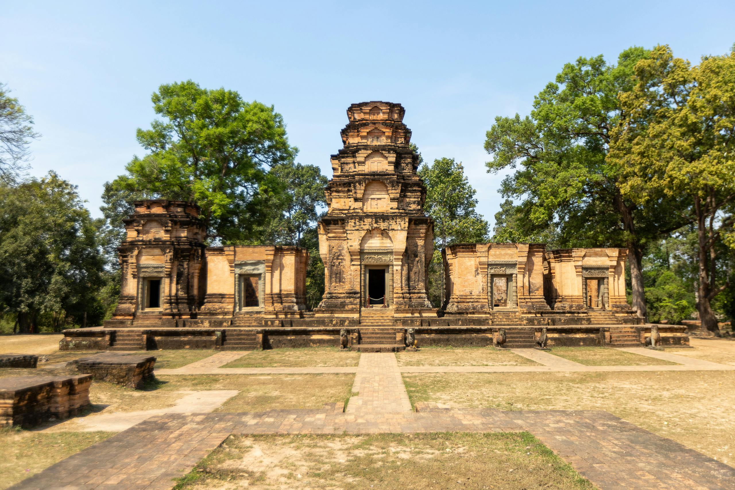 Explore the intricate architecture of a historic Khmer temple surrounded by lush greenery.