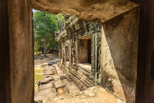 Free Explore the intricate stone carvings and lush surroundings of Angkor Wat's ancient temple ruins. Stock Photo