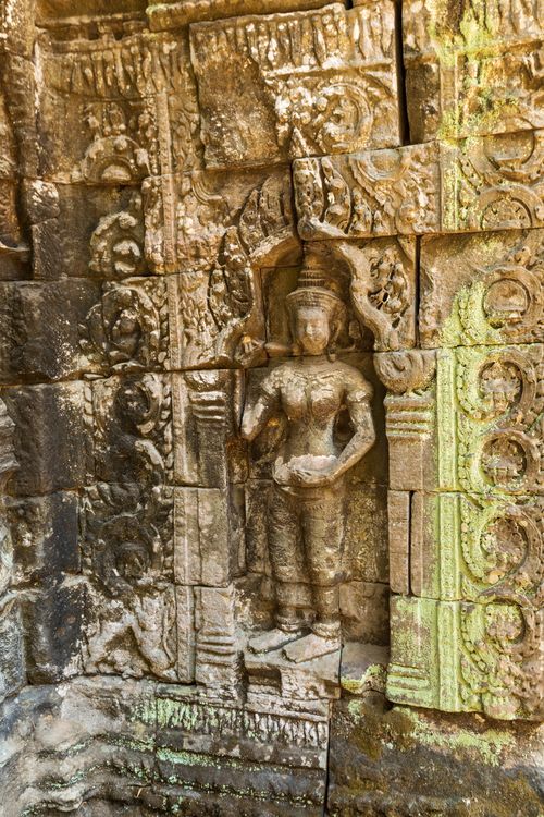 Free Detailed stone carving of a deity at Angkor Wat, showcasing ancient Khmer art and architecture. Stock Photo