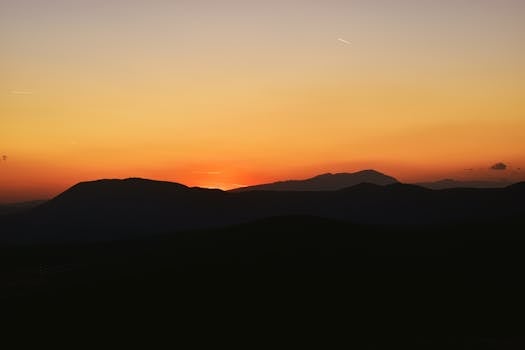 A breathtaking sunset casting a warm glow over rolling hills in Bosnia and Herzegovina.
