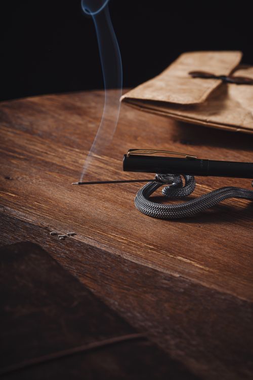 Free A cozy scene with incense burning on a wooden desk, creating a serene atmosphere. Stock Photo