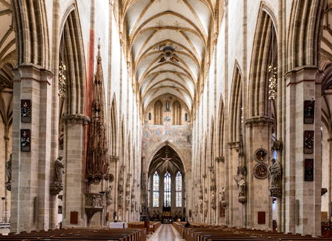 Detailed view of the Gothic interior of Ulm Cathedral, showcasing vaulted ceilings and colonnades.