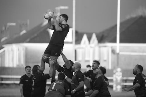 Men in Uniform Playing Rugby on Field