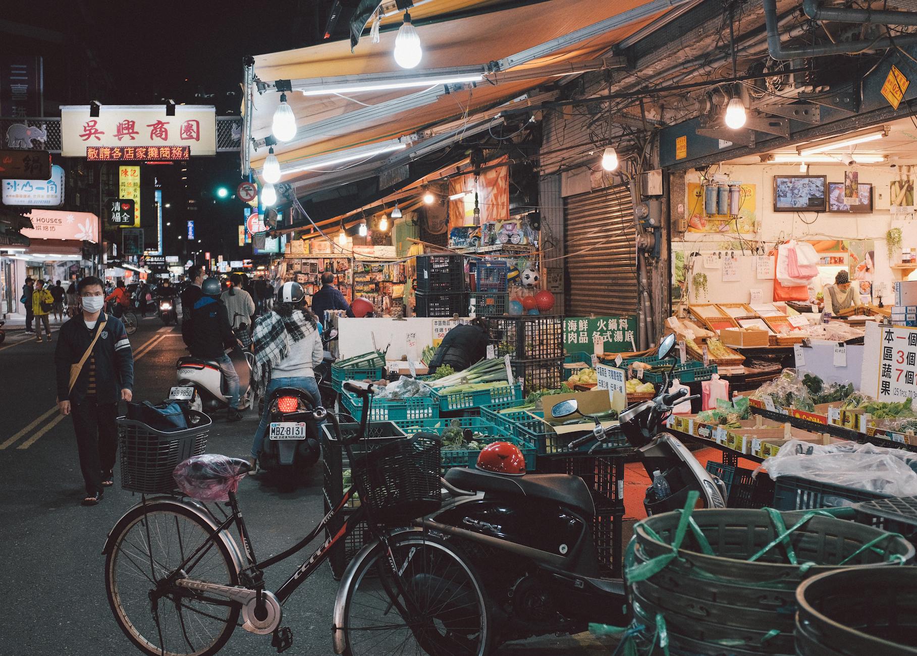 Bustling night market in Taipei with shoppers and vendors, showcasing vibrant city life.