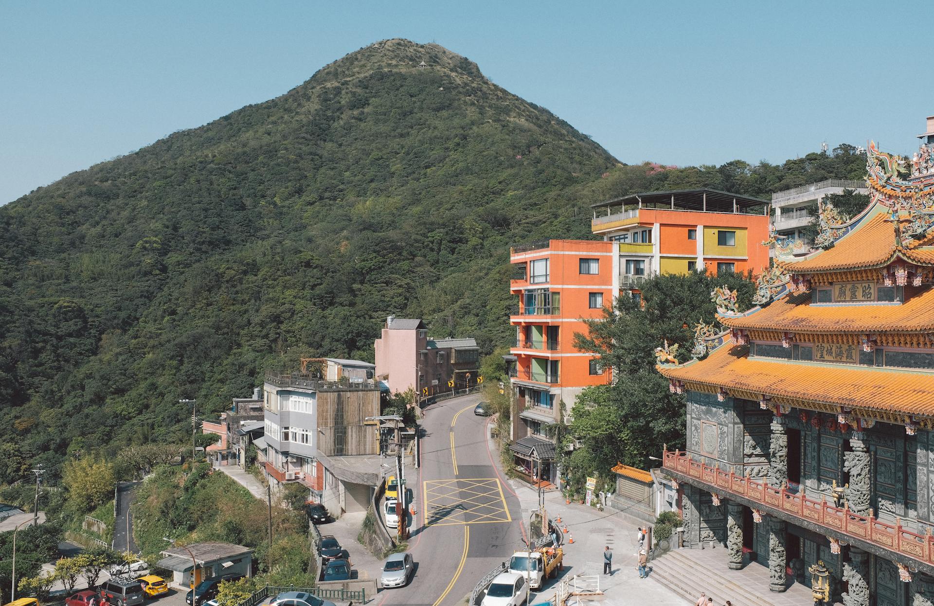 Explore vibrant Taiwanese architecture set against lush mountains in a bright urban landscape.