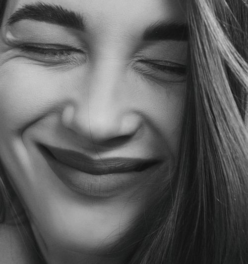 Free Expressive black and white close-up of a smiling woman with sleek hair. Stock Photo
