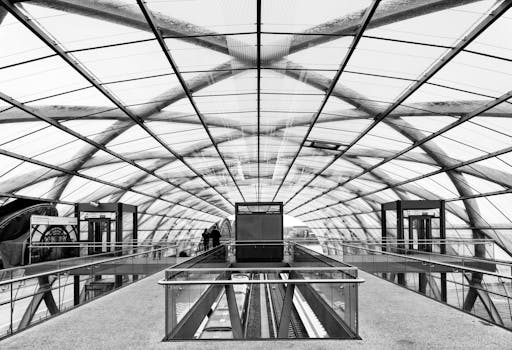 Arched glass ceiling with elevators at a modern Hamburg train station.