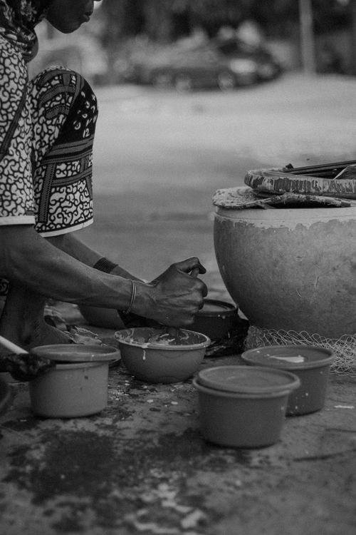 Free Black and white photo of a person preparing food on the streets of Niamey, Niger. Stock Photo