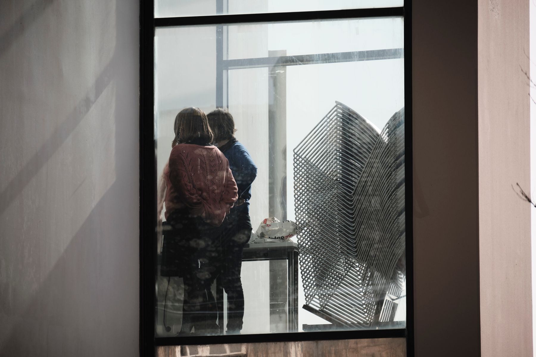 Two people looking out over the city from an office window