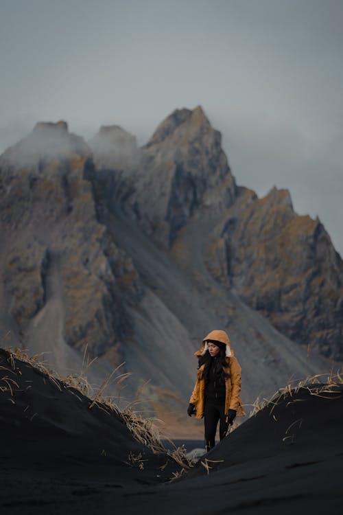 Woman Walking in Rocky Mountains on a Black Soil Terrain