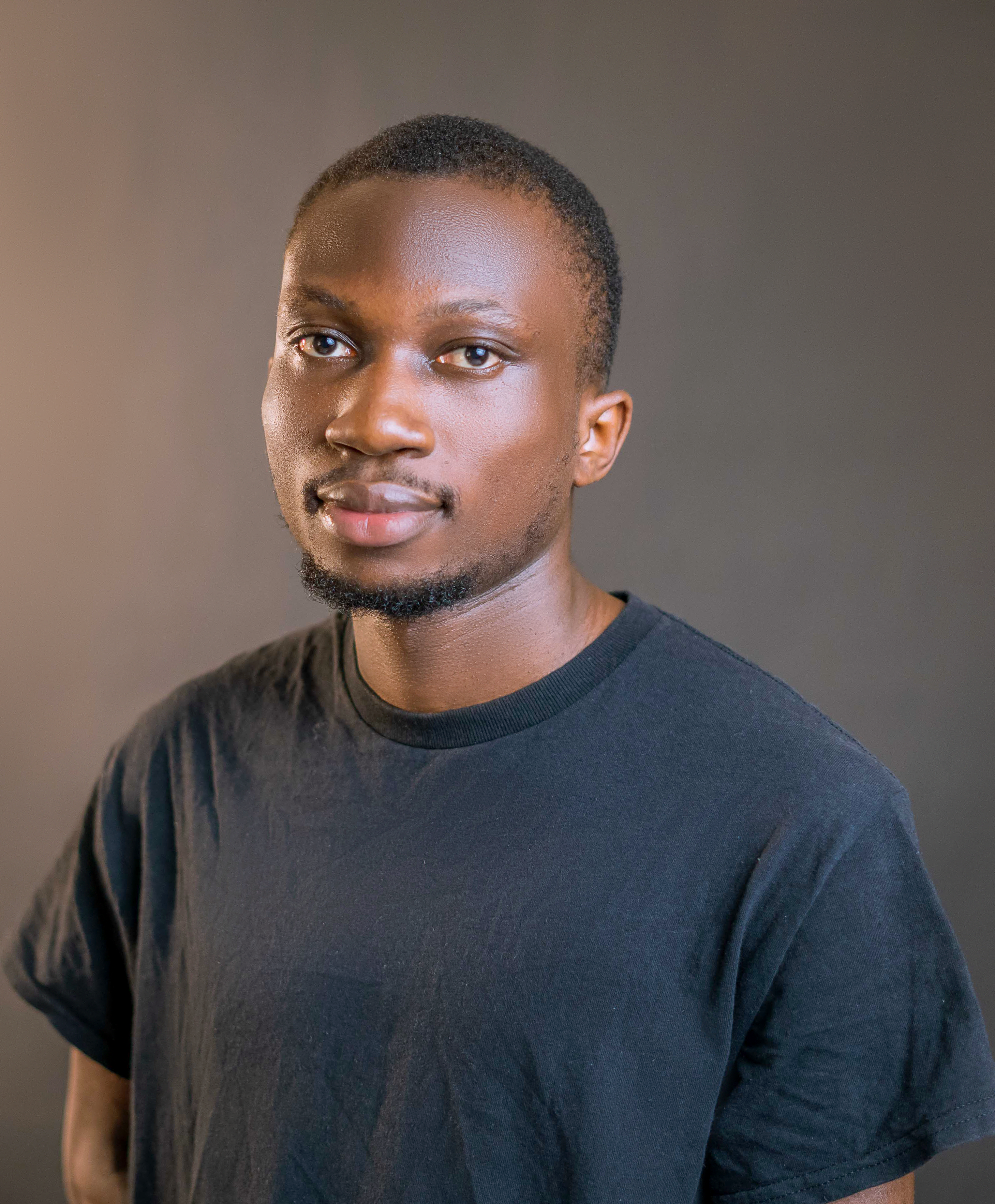 Professional studio portrait of a young man in a black t-shirt.