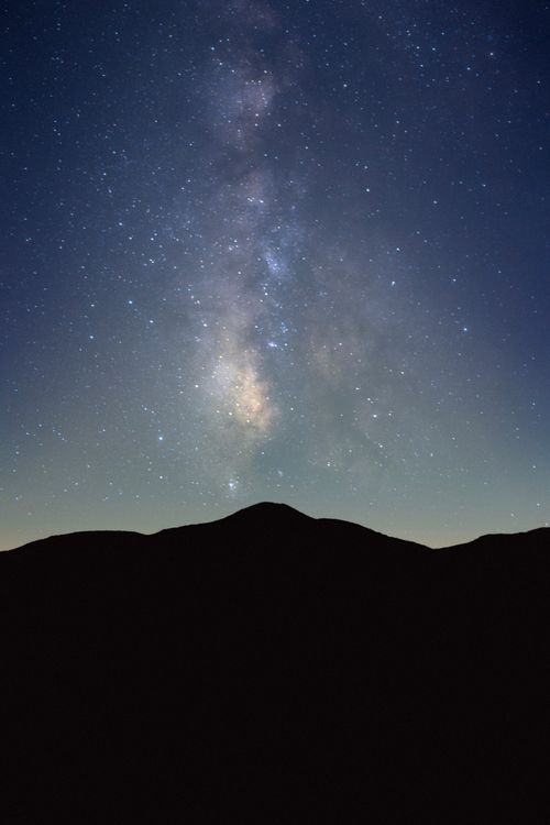 Free A breathtaking view of the Milky Way galaxy illuminating the night sky above a mountain silhouette. Stock Photo