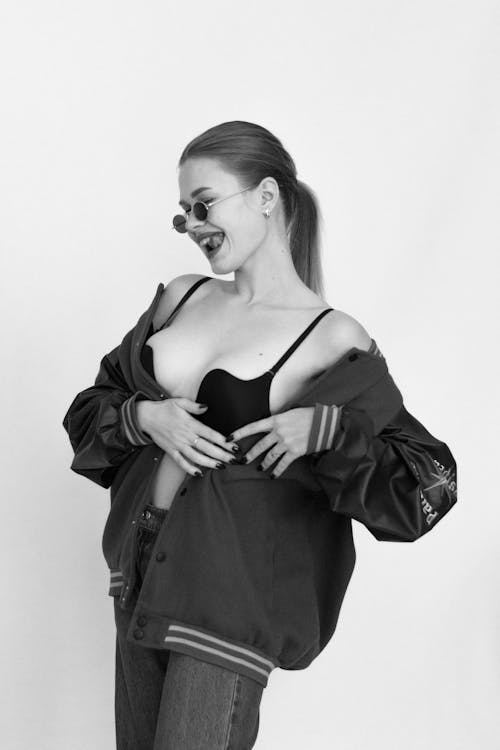 Black and White Photo of a Smiling Young Woman in a Bra and Jacket