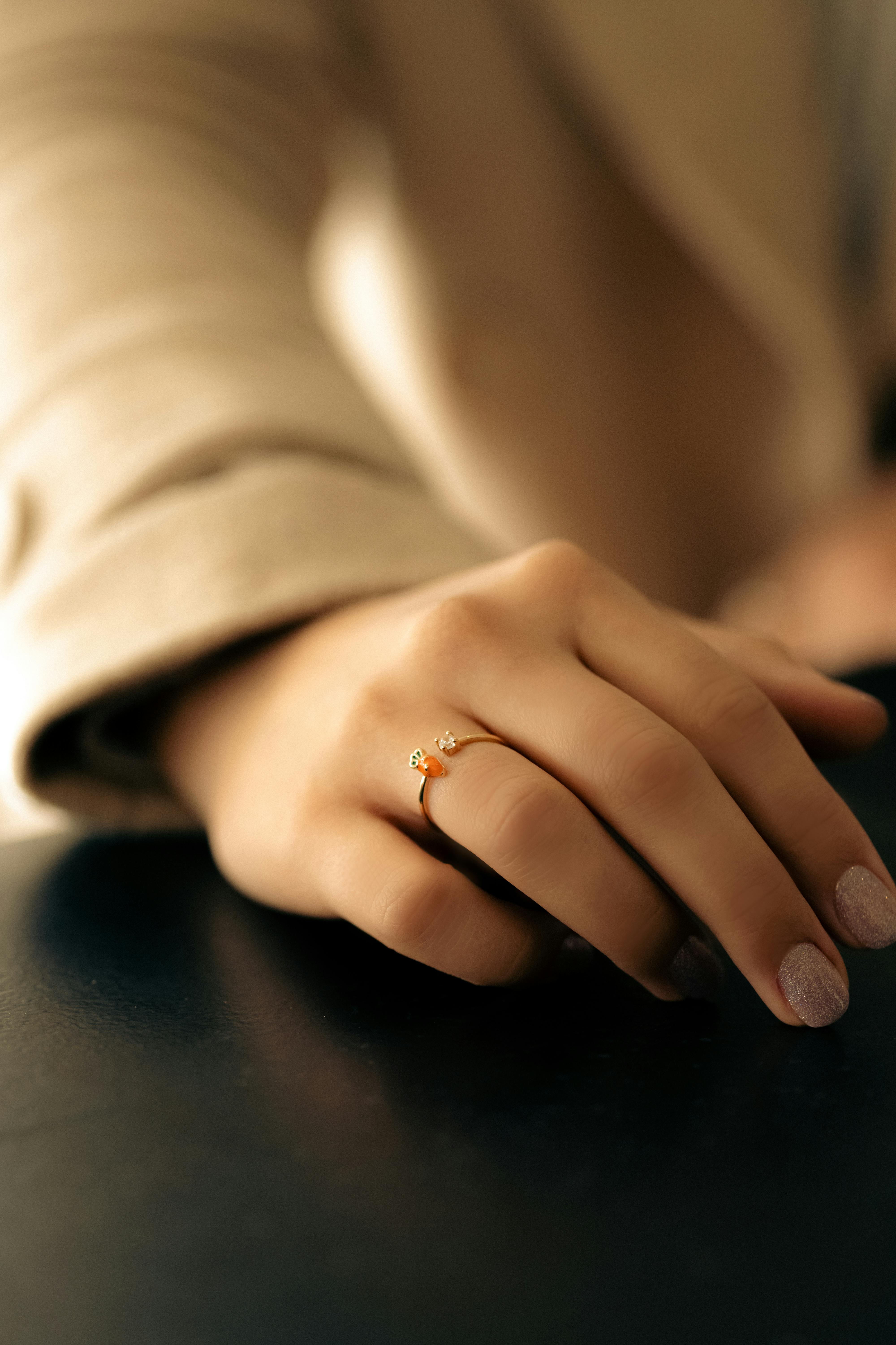 hand with ring lying on a black table