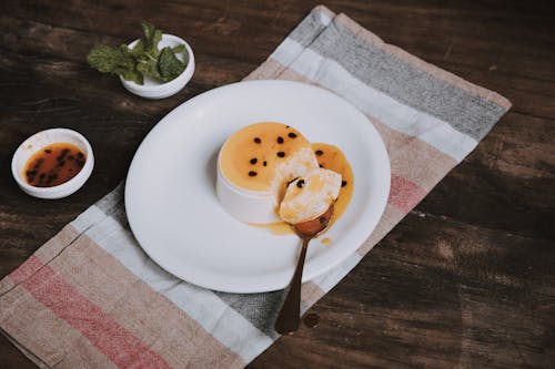 Flan Dessert with Passion Fruit Sauce on a Plate, and Striped Tea Towel