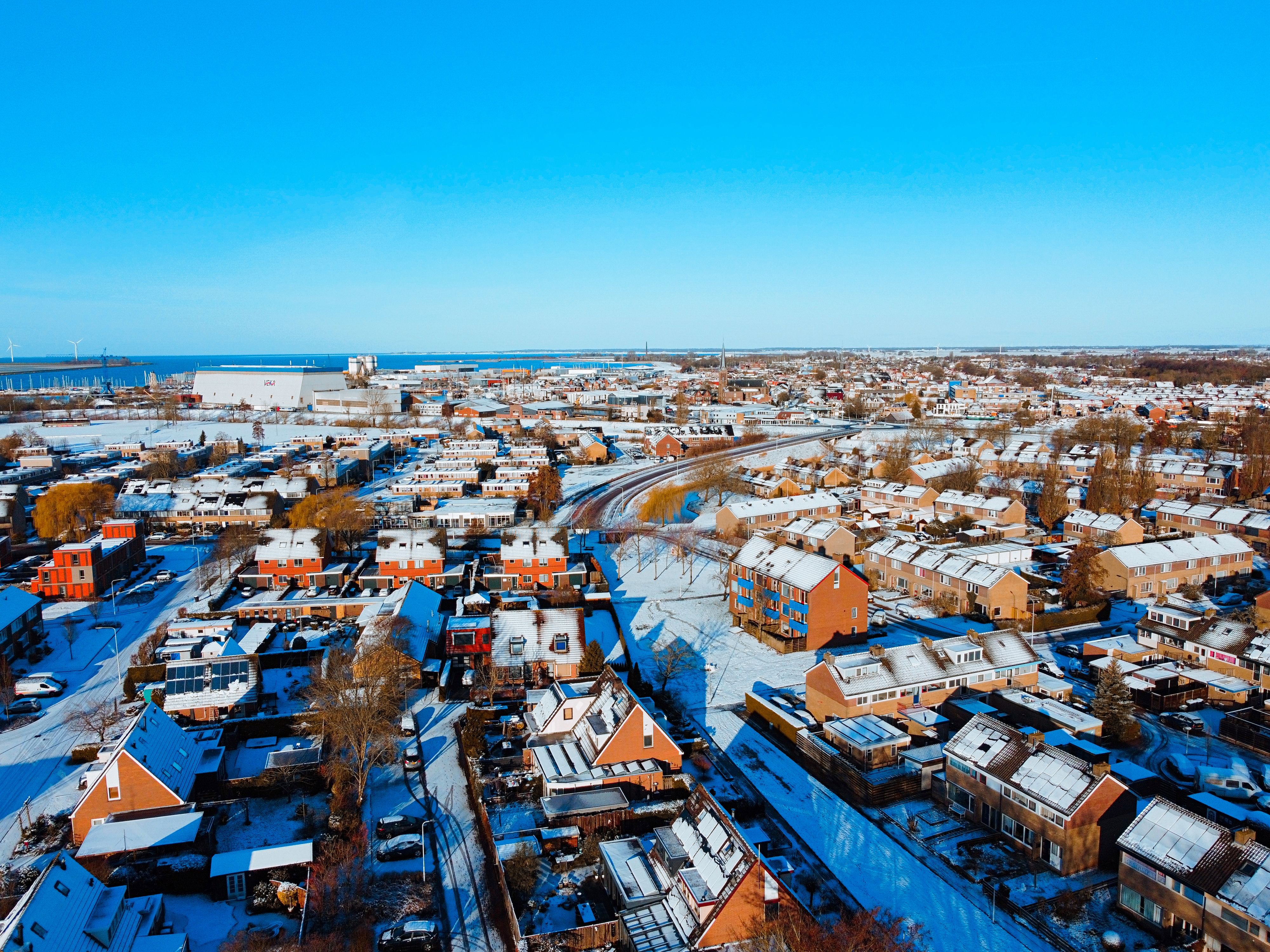 Aerial View of Houses Covered in Snow in a Coastal City · Free Stock Photo