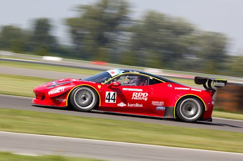 Coche De Carreras Rojo En La Pista De Carreras Durante El Día