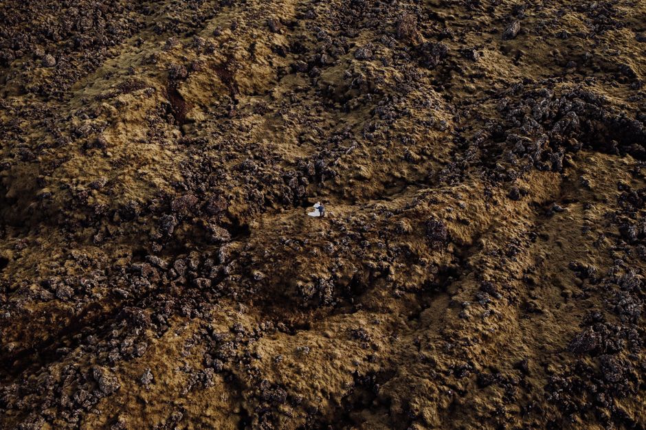Amazing Iceland Volcanic Eruption Area Helicopter Tour from Reykjavík Review Review 2026 - A couple sits amidst the rocky wilderness of Vik, Iceland, view from above.