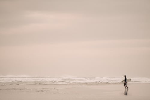 Surfer Running Towards Ocean