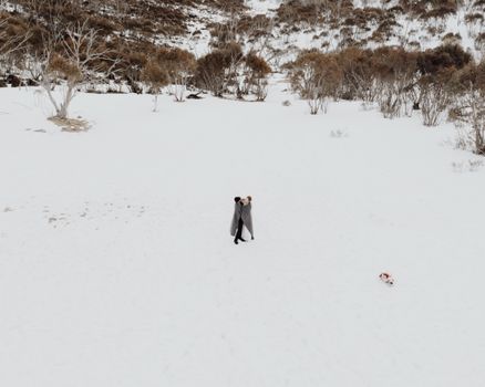A romantic couple embracing in a snowy landscape, symbolizing love and intimacy.
