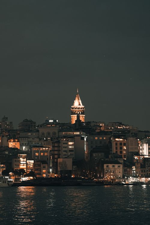 Free Illuminated Galata Tower shining over Istanbul's skyline at night. Stock Photo