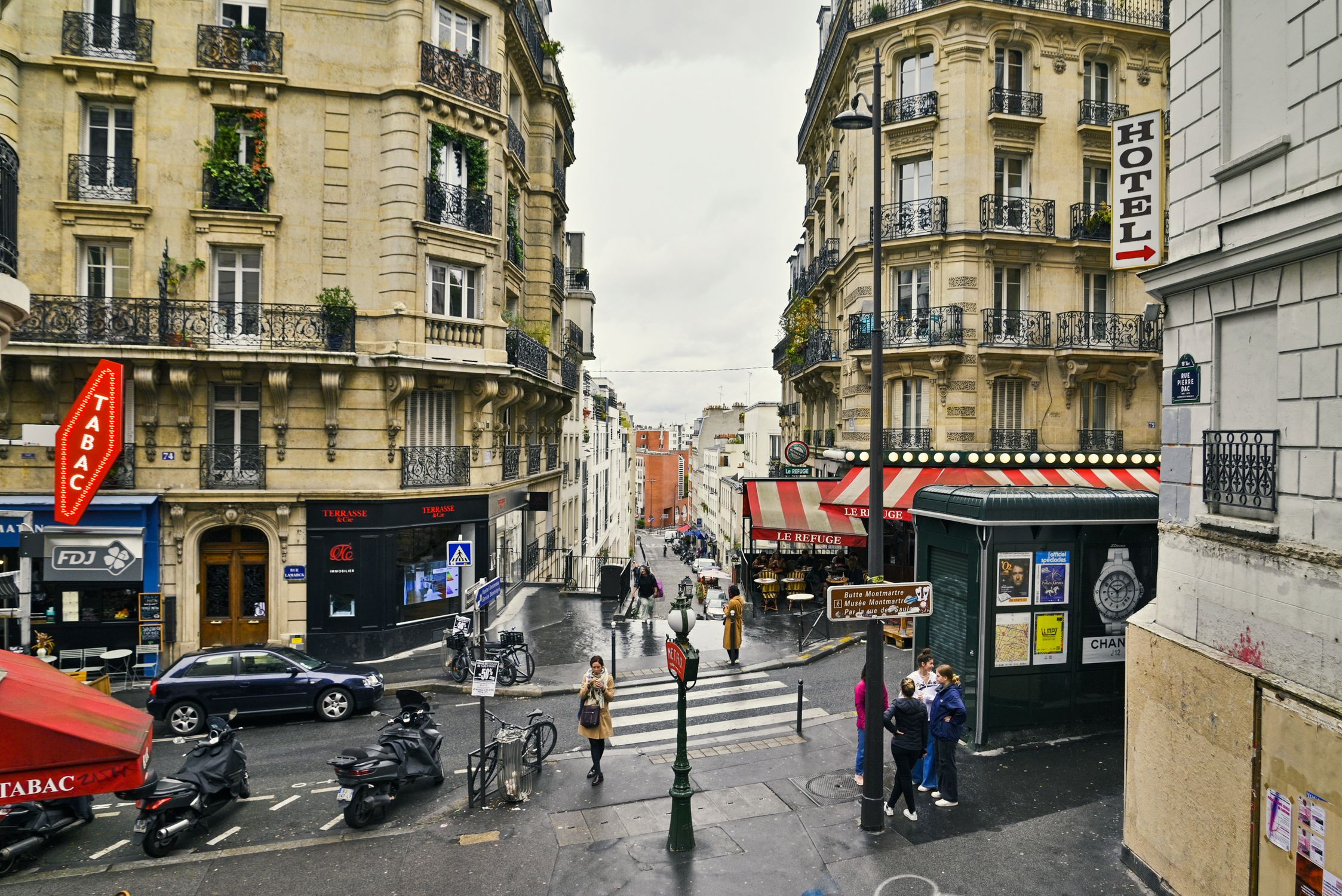 Lively street scene in Montmartre, Paris featuring classic architecture and bustling activity.