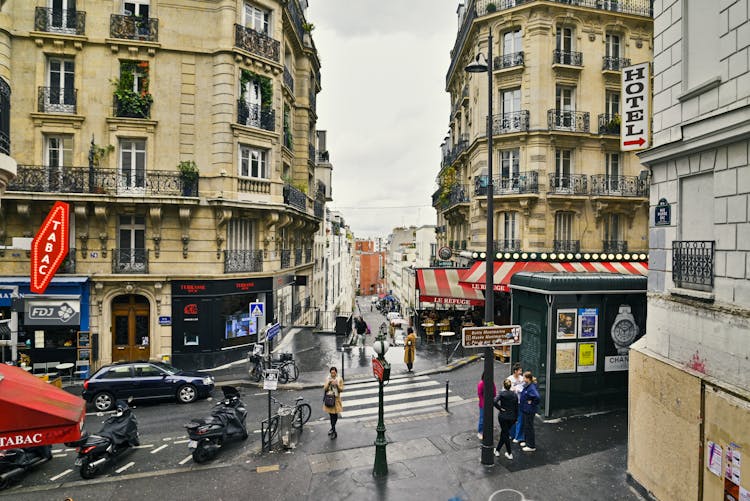 PARIS, FRANCE, OCTOBER, 11 - 2022 - Rue Pierre Dac Montmartre View Over The Street, Shops, Scooters, People, Cafes And Residential Buildings