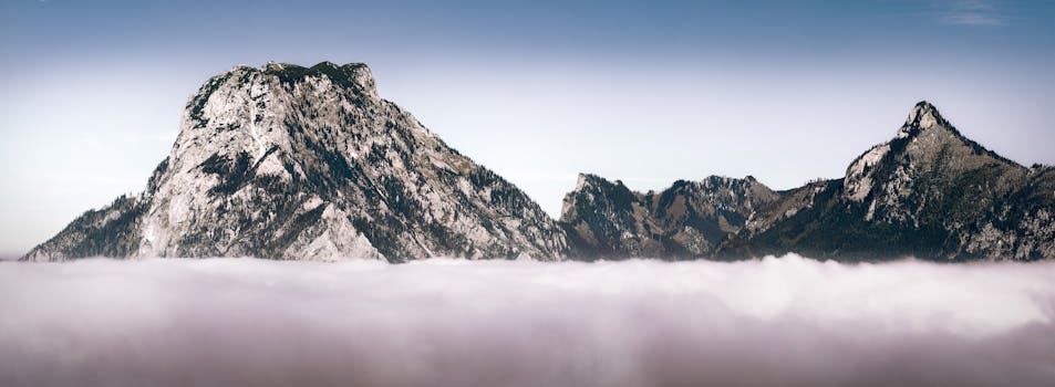 Stunning panoramic view of Austria's rocky mountains above a sea of clouds.