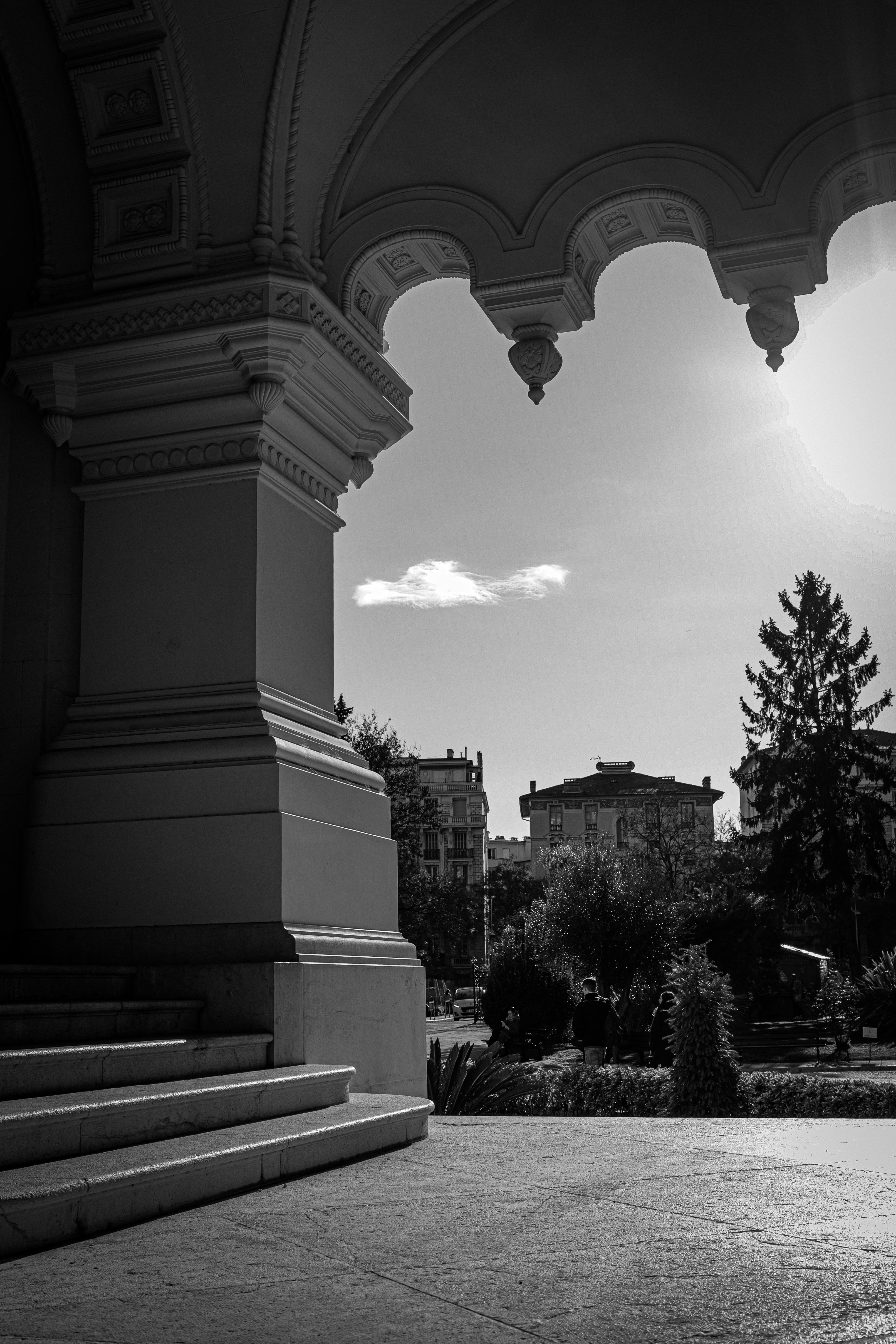 black and white photograph of a building with a sun shining