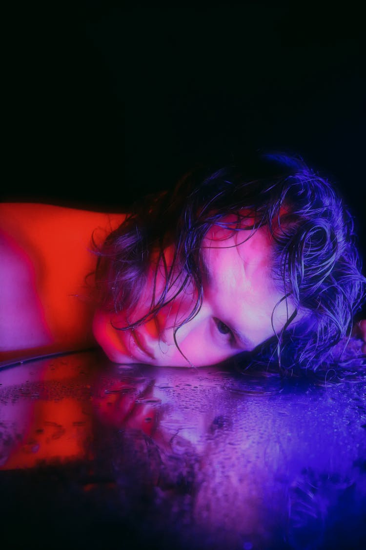 Man Lying Head On Wet Glass Surface