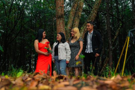 A joyful group of friends enjoying a moment together in a lush forest setting.