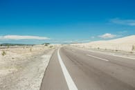 在蔚蓝的天空下，那条穿过干旱景观的漫长高速公路，非常适合旅行或冒险主题