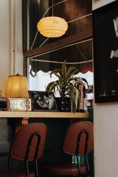 Charming vintage cafe setting featuring leather chairs, retro decor, and warm lighting.