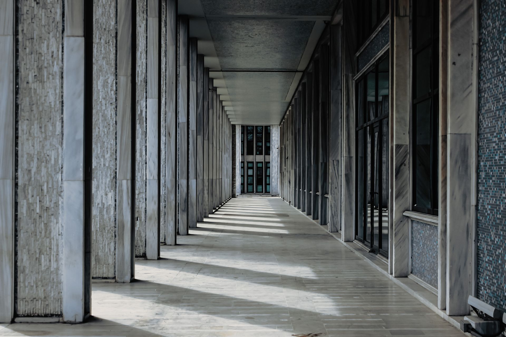 Plan large d'un couloir de palais de justice désert au sol de marbre gris.