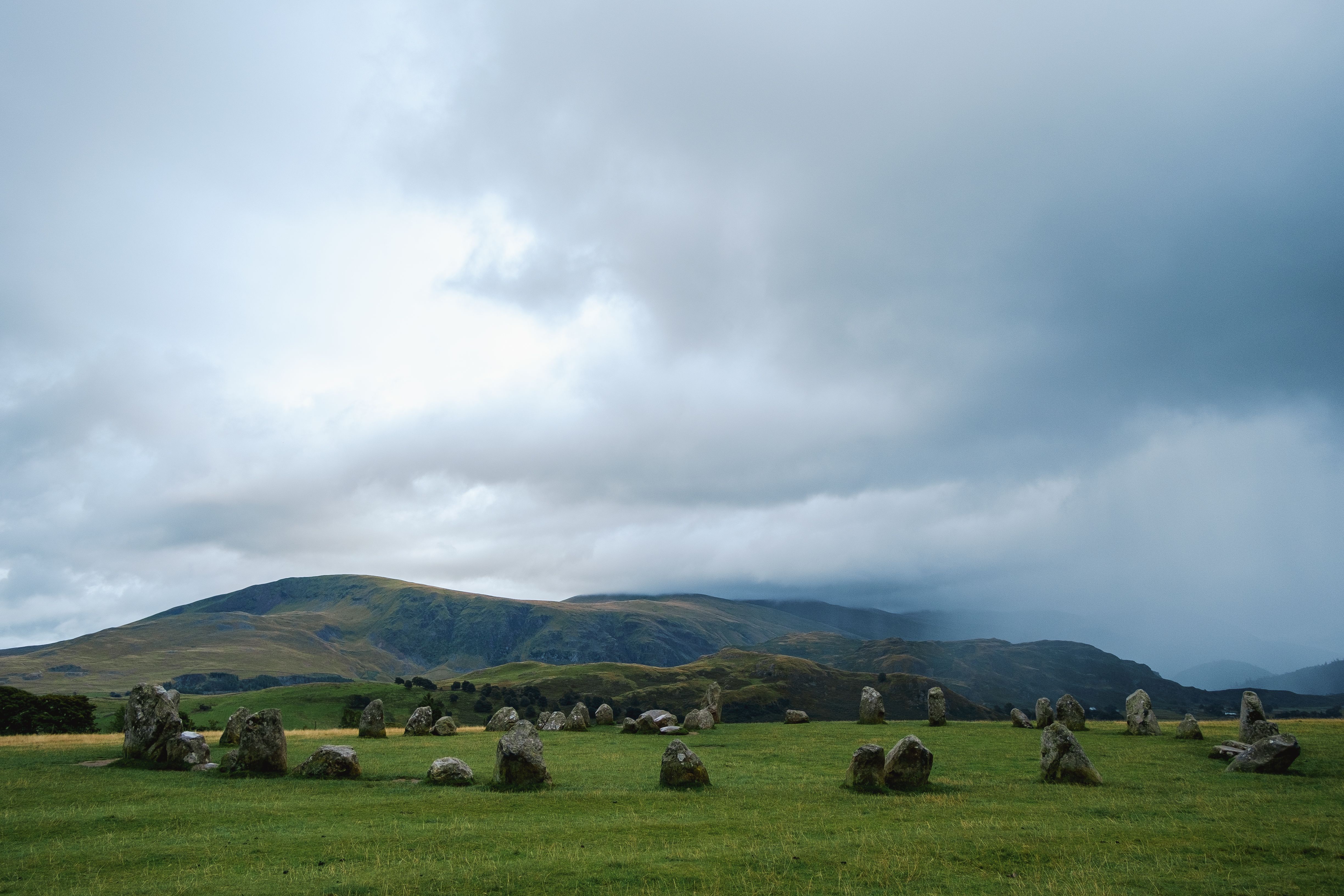Scenic view of the ancient stone circle under cloudy sky in Keswick, England.