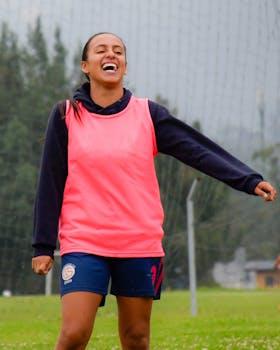 Cheerful young woman soccer player enjoying training session outdoors.